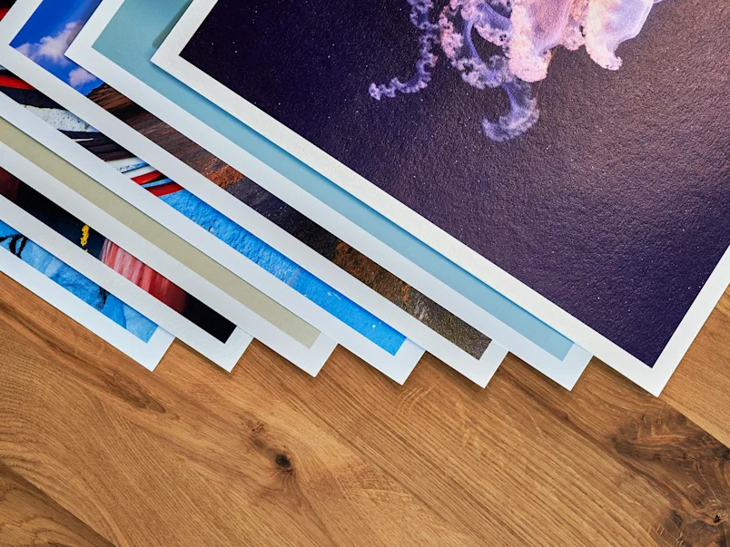 Fine art giclée prints stacked on wood surface