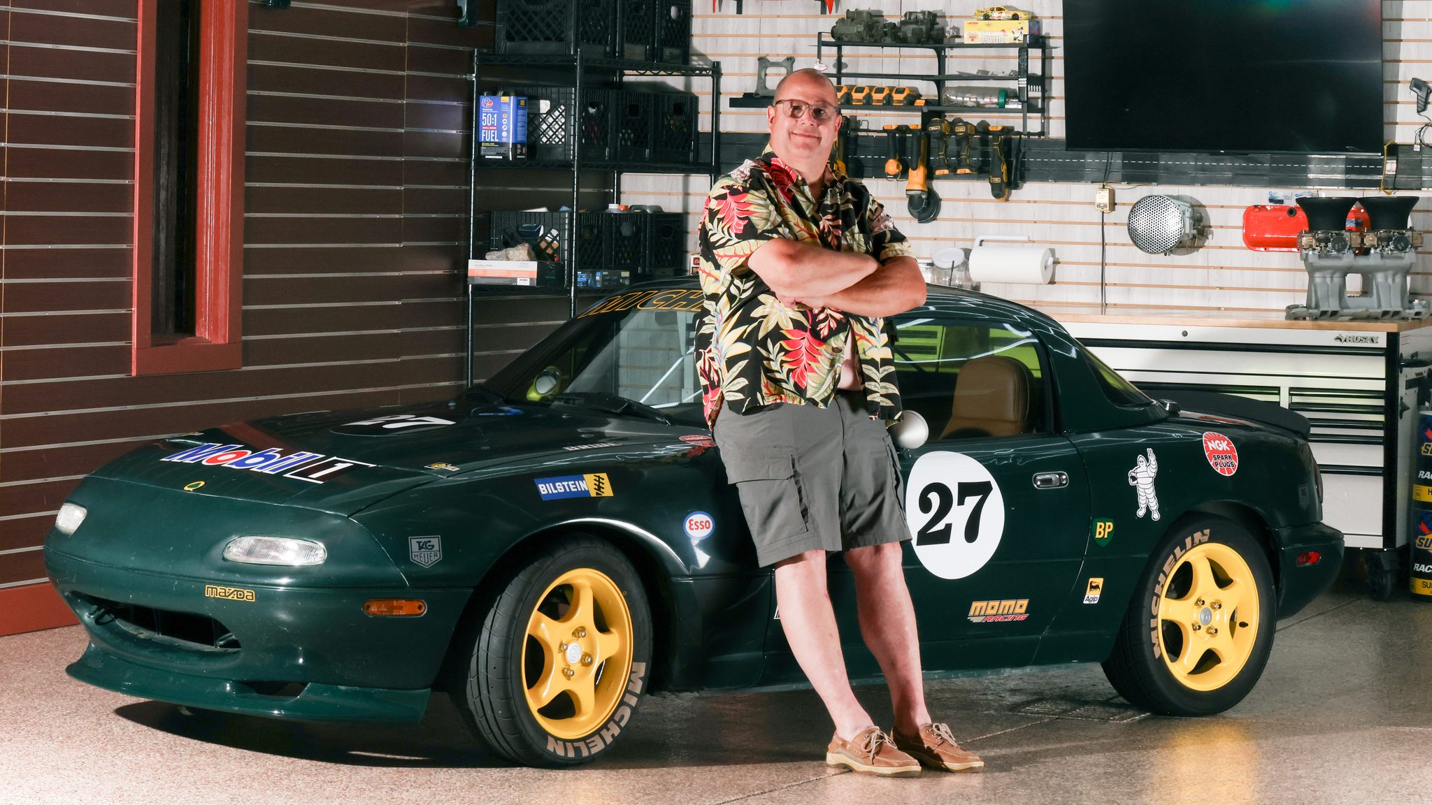 Portrait of a racing enthusiast with his green number 27 Mazda Miata track car in a custom garage — A2 Portraits, Ann Arbor